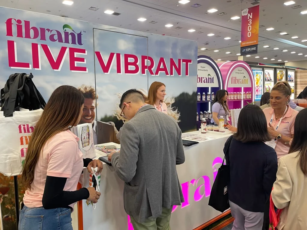 Fibrant team speaking with visitors at a Live Vibrant trade-show booth
