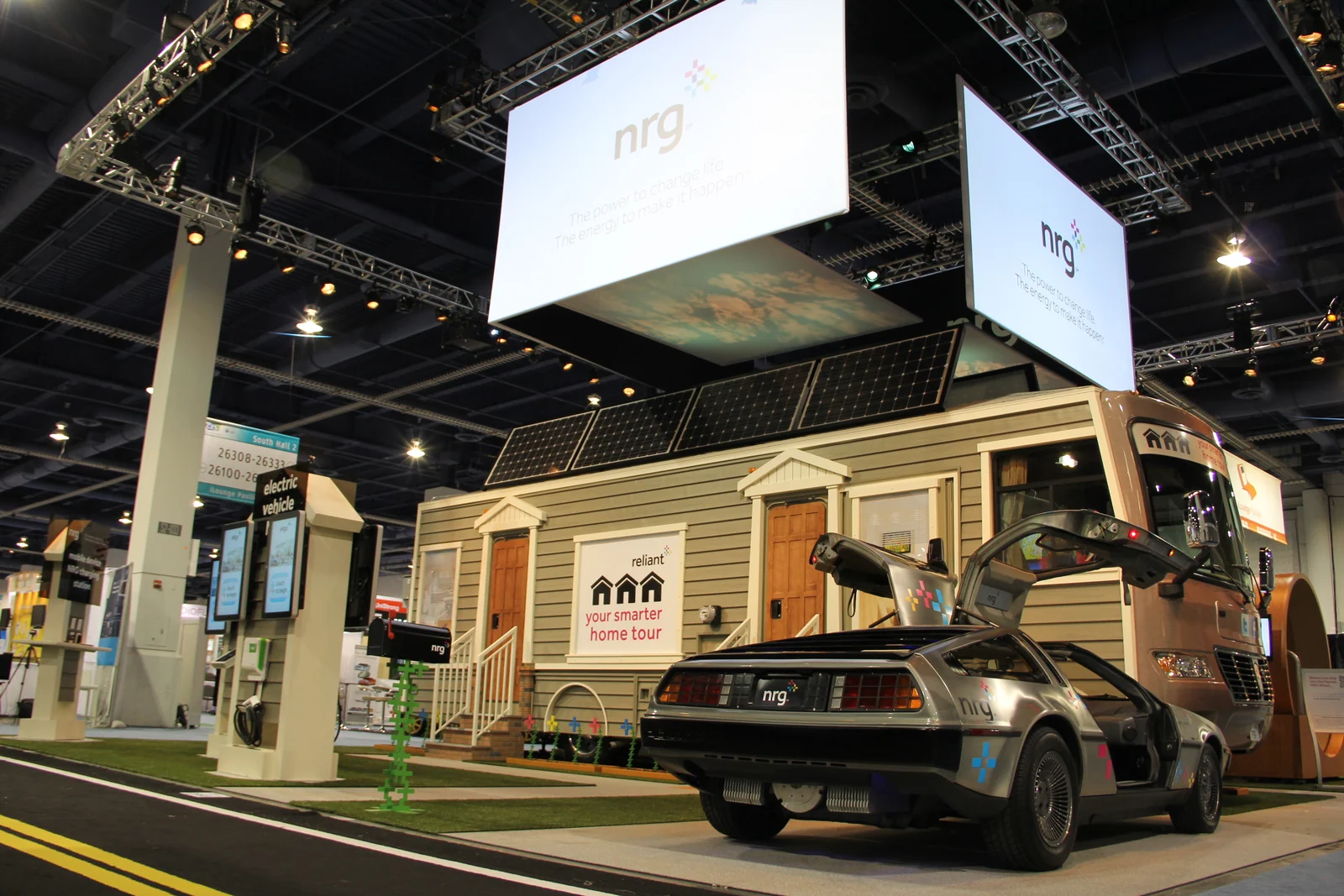 NRG smart-home exhibit with solar panels, charging stations and a DeLorean at a trade show