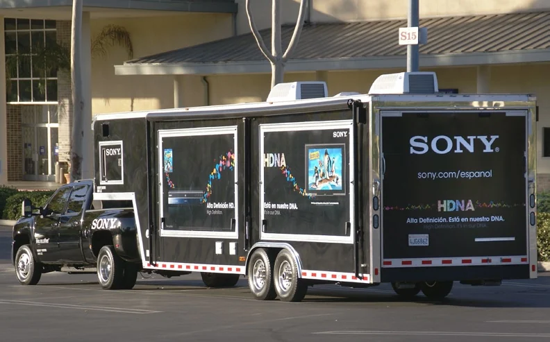 Rear and side of the Sony demonstration trailer parked beside a storefront