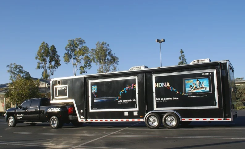 Wide view of the complete Sony truck and trailer beneath a blue sky